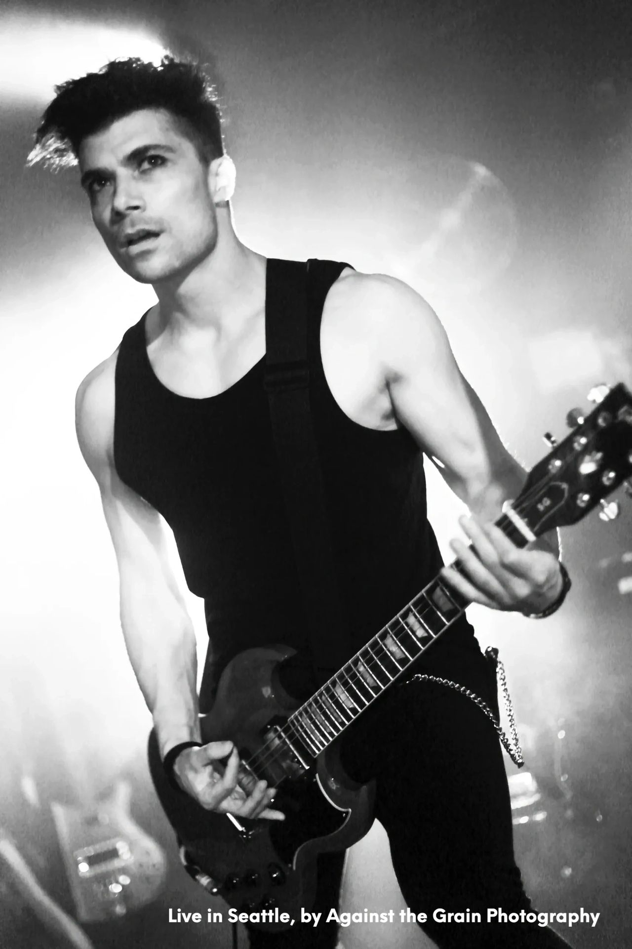 Ben Christo performing live on stage in Seattle — black and white shot from below, dramatic lighting