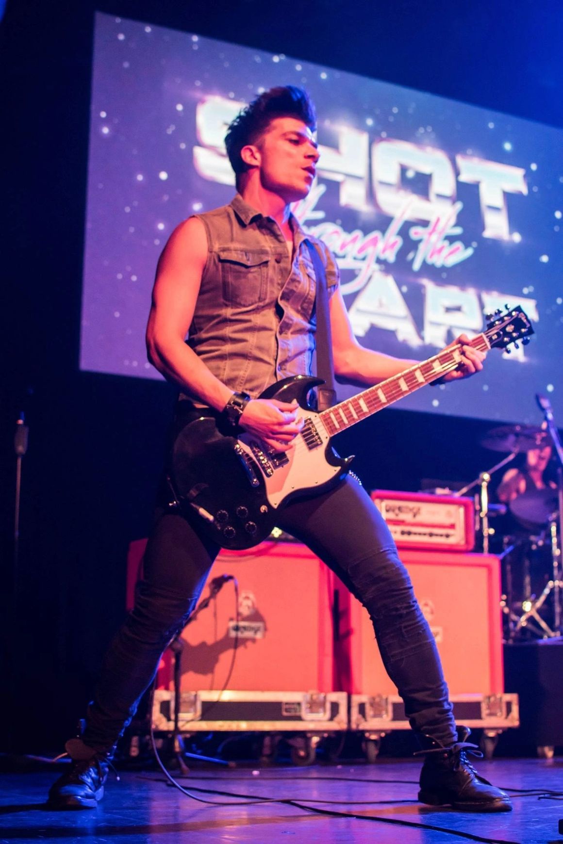 Ben Christo on stage with Night by Night, backdrop reading Shot Through The Stars